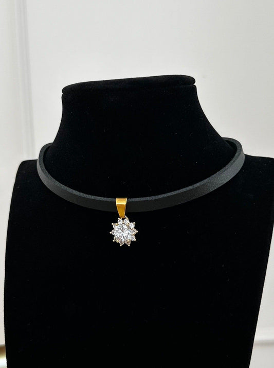 Svart choker i skinn med et blomsteranheng